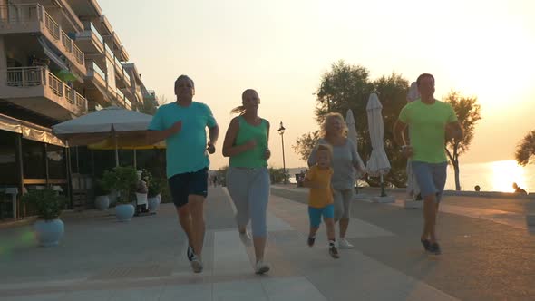 Happy family finishing evening run on resort