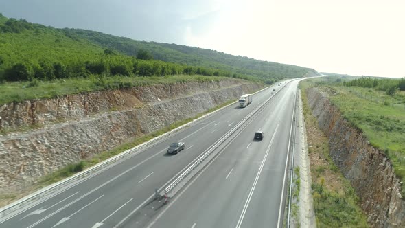 Aerial View of Highway Between Green Hills with Busy Summer Traffic in Hot Day