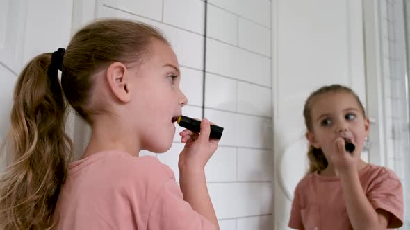 Little Girl Paints Her Lips with Lipstick