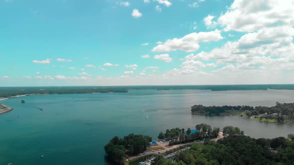 Boats traveling on a lake through rippling water with blue skies behind them in Lake Murray, South C