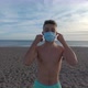 one young man taking off his mask for the coronavirus and starting running to the water - VideoHive Item for Sale