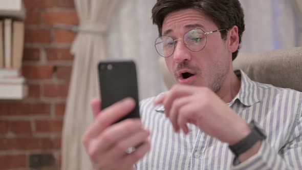 Portrait of Middle Aged Man Reacting to Loss on Smartphone