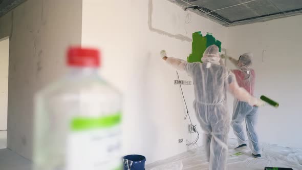 Couple in Transparent Coveralls Runs Waving Hands to Paint