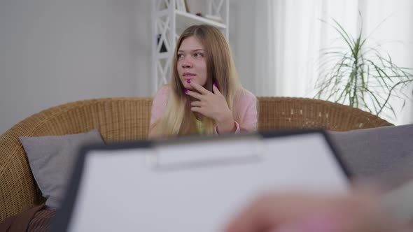 Portrait of Overwhelmed Hysterical Millennial Woman Talking with Blurred Female Hand Writing at