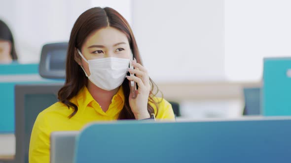 New normal of Asian woman in yellow shirt wearing surgical face mask talking with customer