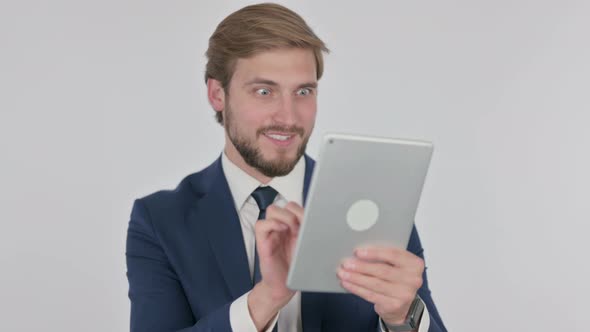 Young Businessman Celebrating Success on Tablet on White Background