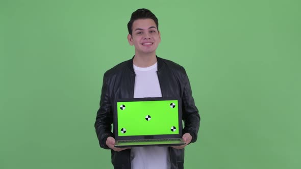 Happy Young Handsome Multi Ethnic Man Thinking While Showing Laptop