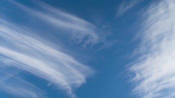 A timelapse of beautiful white clouds moving across the blue sky like strokes on a painting