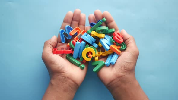 Colorful Plastic Letters on Child Hand