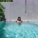 Cute Asian Girl Alone In Swimming Pool Smiling In Resort On Sunny Day SlowMotion - VideoHive Item for Sale