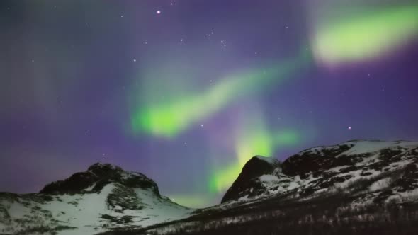 colorful winter aurora in mountainous landscape