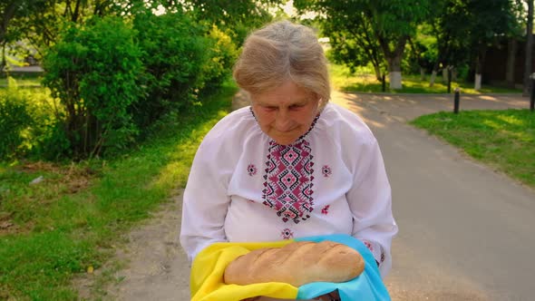 Grandmother with Ukrainian Bread in Her Hands