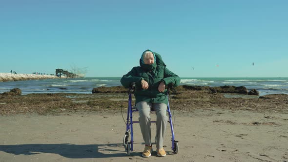 Greyhaired Old Woman Sits on Wheelchair Walker Near Lagoon