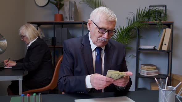 Rich Senior Business Manager Counting Money Dollar Cash After Working on Portable Laptop at Office