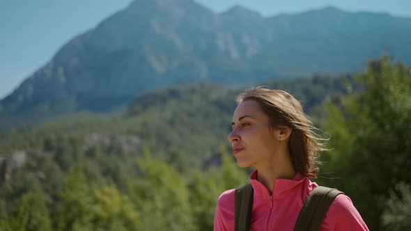 Happy Attractive Woman Tourist Enjoys Breathing Fresh Air High in Woody Mountains at Sunny Day