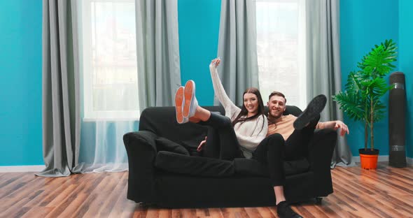 A Happy Young Couple is Bringing a Couch to Their New Home