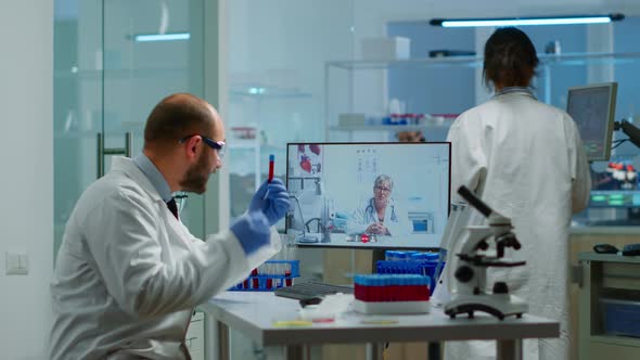 Male Chemist Listening Professional Doctor on Video Call