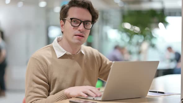 Man Showing No Sign While Working on Laptop