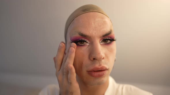 Closeup Front View Confident Extravagant Travesty Woman Adjusting False Eyelashes Looking at Camera