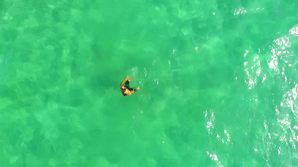 Aerial view of a man swimming in a green lake