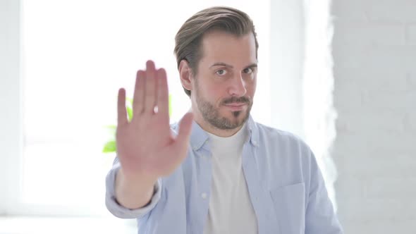 Portrait of Rejecting Young Man Showing Stop Sign