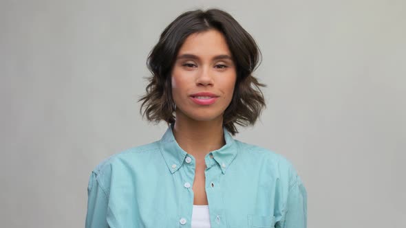 Smiling Woman in Turquoise Shirt Showing Thumbs Up