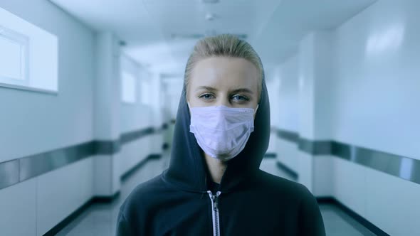 Woman Wearing Face Mask Because of Air Pollution or Virus Epidemic in the Hospital Corridor