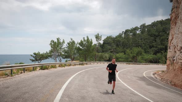 Man jogging on road in mountain forest