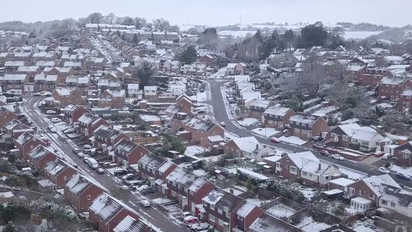 Low dolly forward drone shot of snowy Exeter subburbs