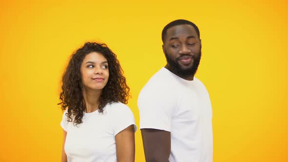 Beautiful Multiracial Couple Flirting and Smiling, Isolated on Yellow Background