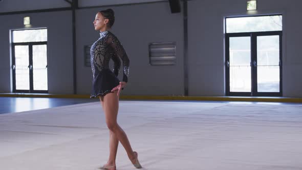 Teenage female gymnast performing at sports hall