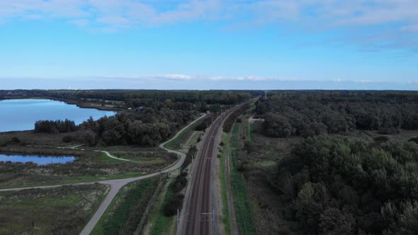 Dutch railway track true the polder on a covid summer day. Drone shot