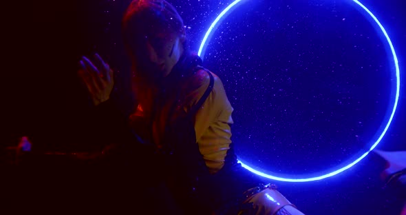 a Girl Hovers in the Dark Under the Water Against the Background of a White Shimmering Hoop