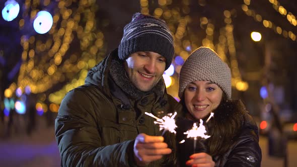 Cute Young Couple Holding Sparklers