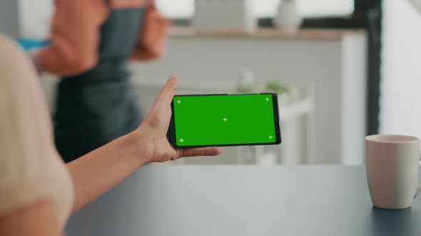 Freelancer Holding Smartphone with Mock Up Green Screen