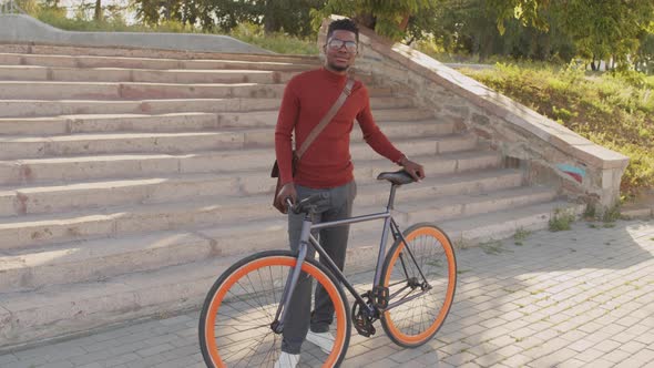 Portrait of Man with Bike in Park on Sunny Day