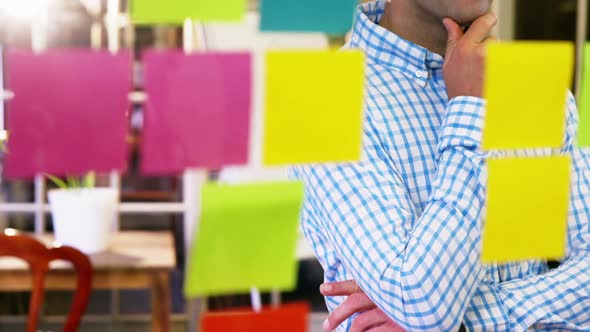 Male business executive looking at sticky notes