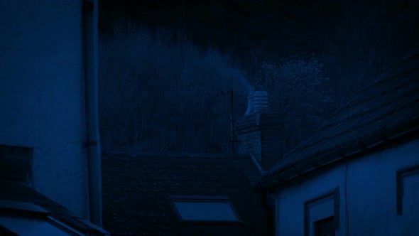 House In Rural Area With Smoking Chimney At Night