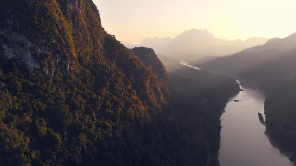 Aerial: flying over Nam Ou River Nong Khiaw Muang Ngoi Laos, sunset dramatic sky