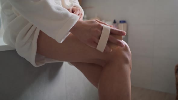 Close up of unrecognizable woman doing peeling of her legs in the domestic bathroom. Shot with RED h