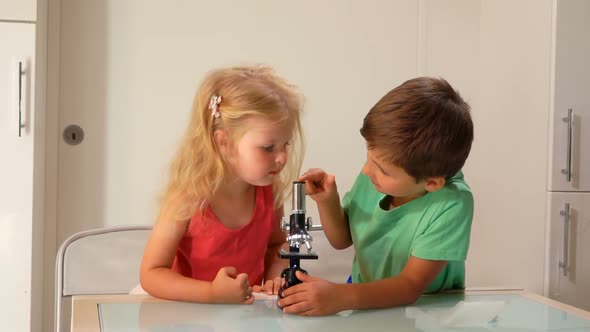 Little Boy and Girl Examine Microscope