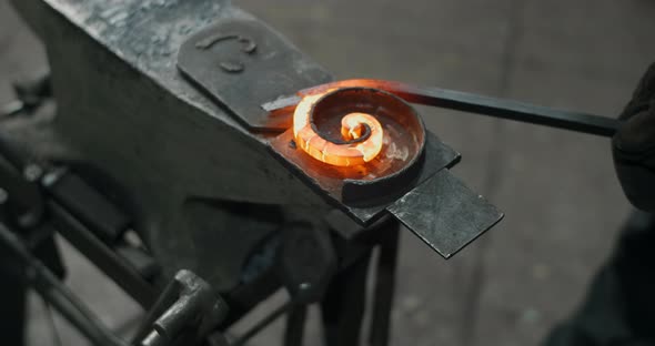 Blacksmith Bends a Redhot Metal Rod on an Anvil Into a Spiral Decorative Blacksmith Craft Forged