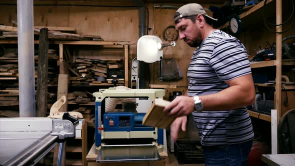 Male Carpenter is Working with Cabinet Planer Machine at Wood Workshop