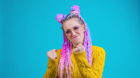 Funny Young Woman with Original Style of Hair Dancing in Studio Blue Background