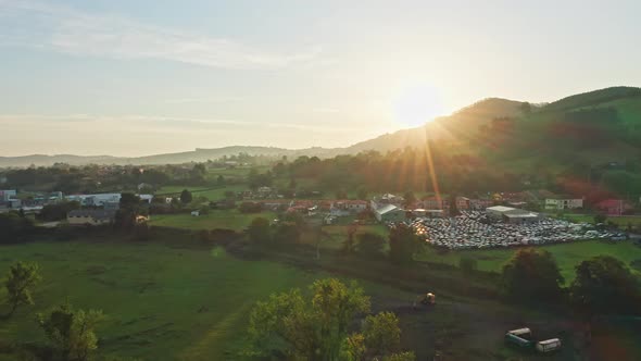 Scenic aerial view of little hamlet in green valley under idyllic sunset