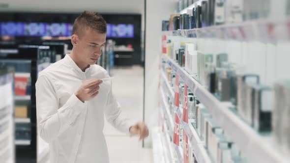 Young Stylish Caucasian Man Testing Perfume Aromas in a Perfume Store