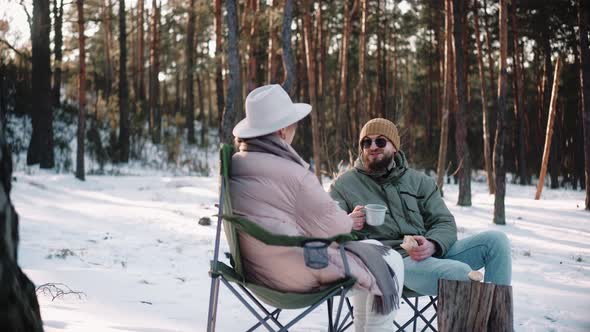 Couple of Travellers Resting in the Woods on Sunny Winter Day Enjoying Van Life