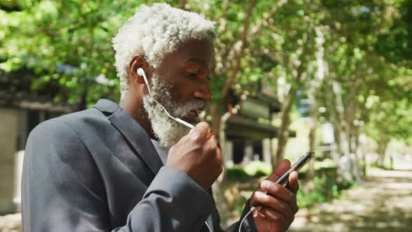 African american senior man talking on smartphone in corporate park