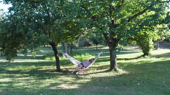 Happy joyful woman swinging in a hammock outdoors