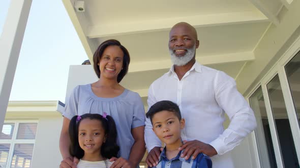 Low angle view back family standing on porch and looking at camera in a comfortable home 4k